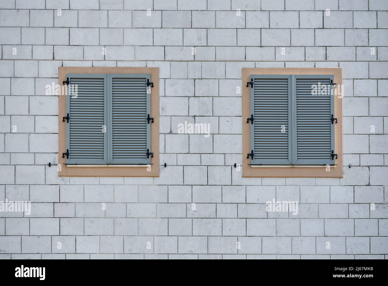 Finestra grigia in plastica che si inforra su una parete di mattoni Foto Stock