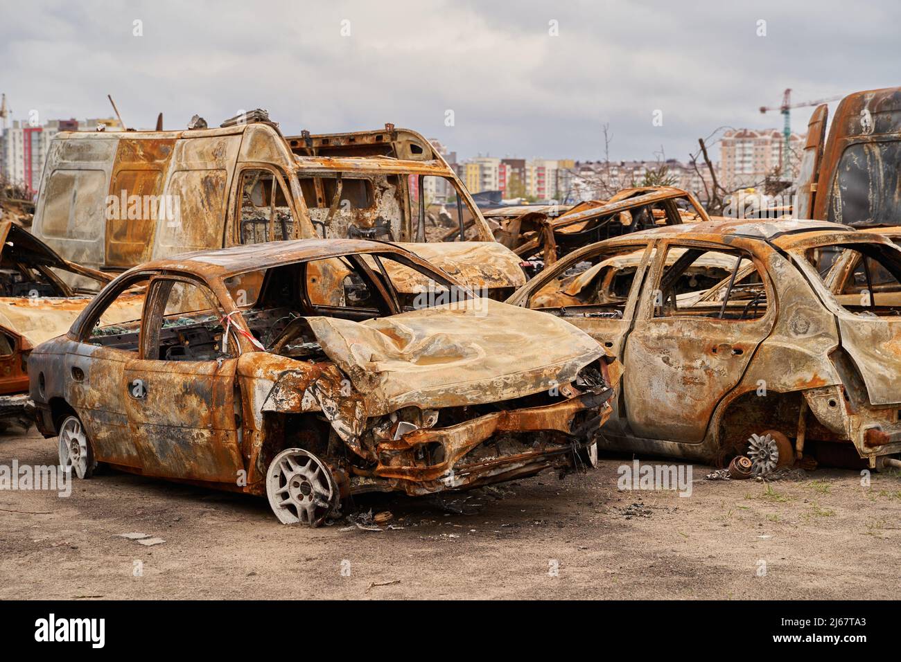 2022 l'invasione russa dell'Ucraina la guerra lacerò la città distrusse l'automobile bruciare. Russia guerra danni costruzione distruzione città guerra rovina città danni auto. Terrore a Foto Stock