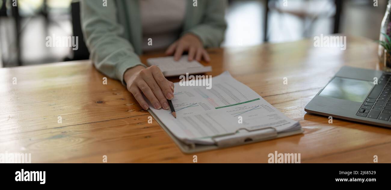 Primo piano un contabile che lavora sul finanziario con calcolatrice in ufficio per calcolare le spese, concetto di contabilità Foto Stock