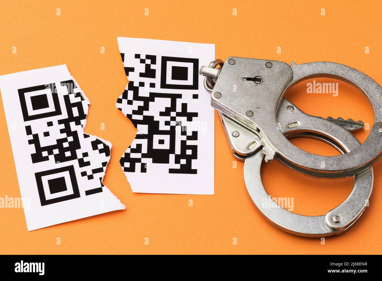 Manette e un foglio con un codice a barre strappato a metà, il concetto di punizione per la contraffazione codici QR, vista dall'alto Foto Stock