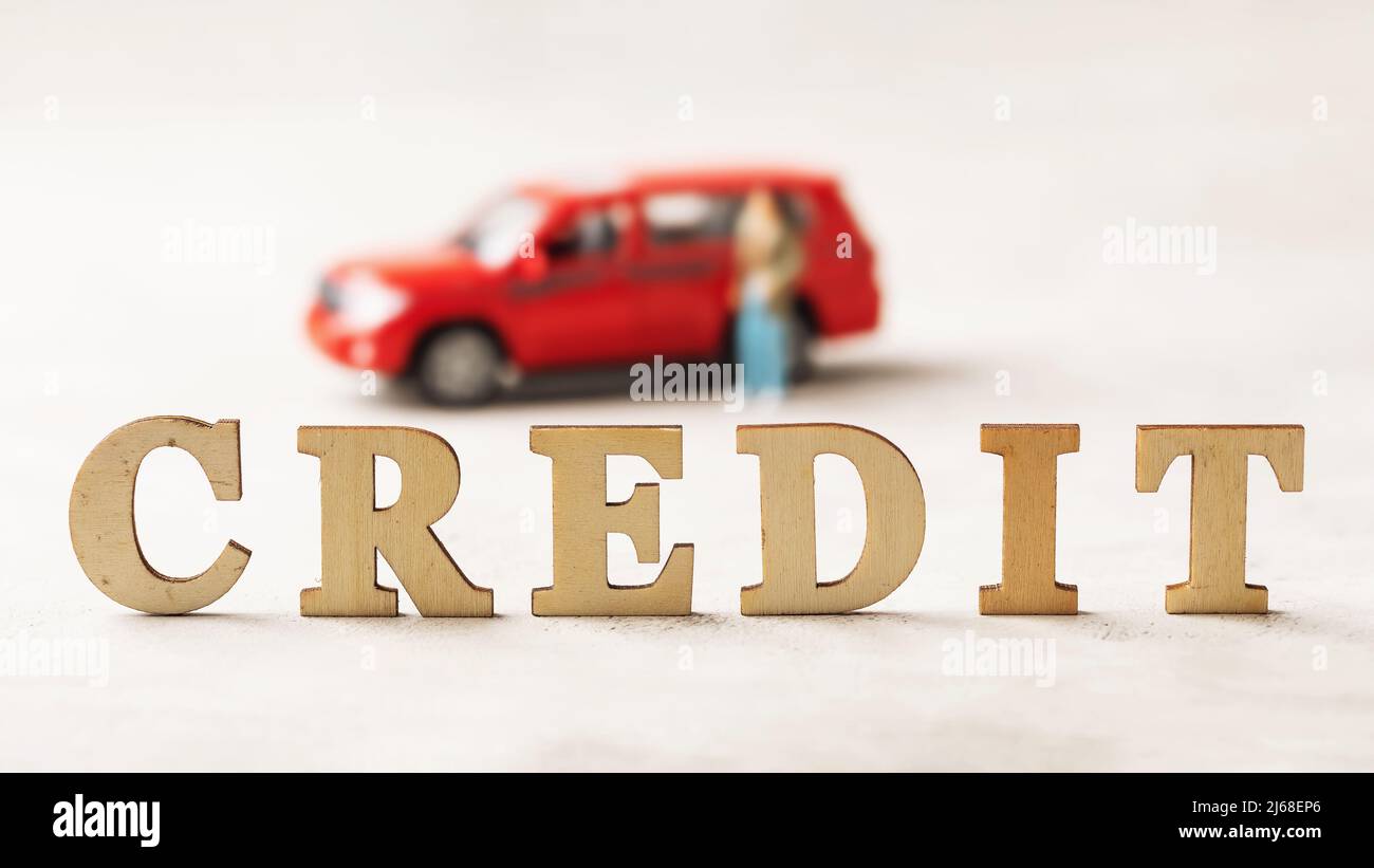 Testo di lettere in legno su sfondo astratto, concetto di prestito auto Foto Stock