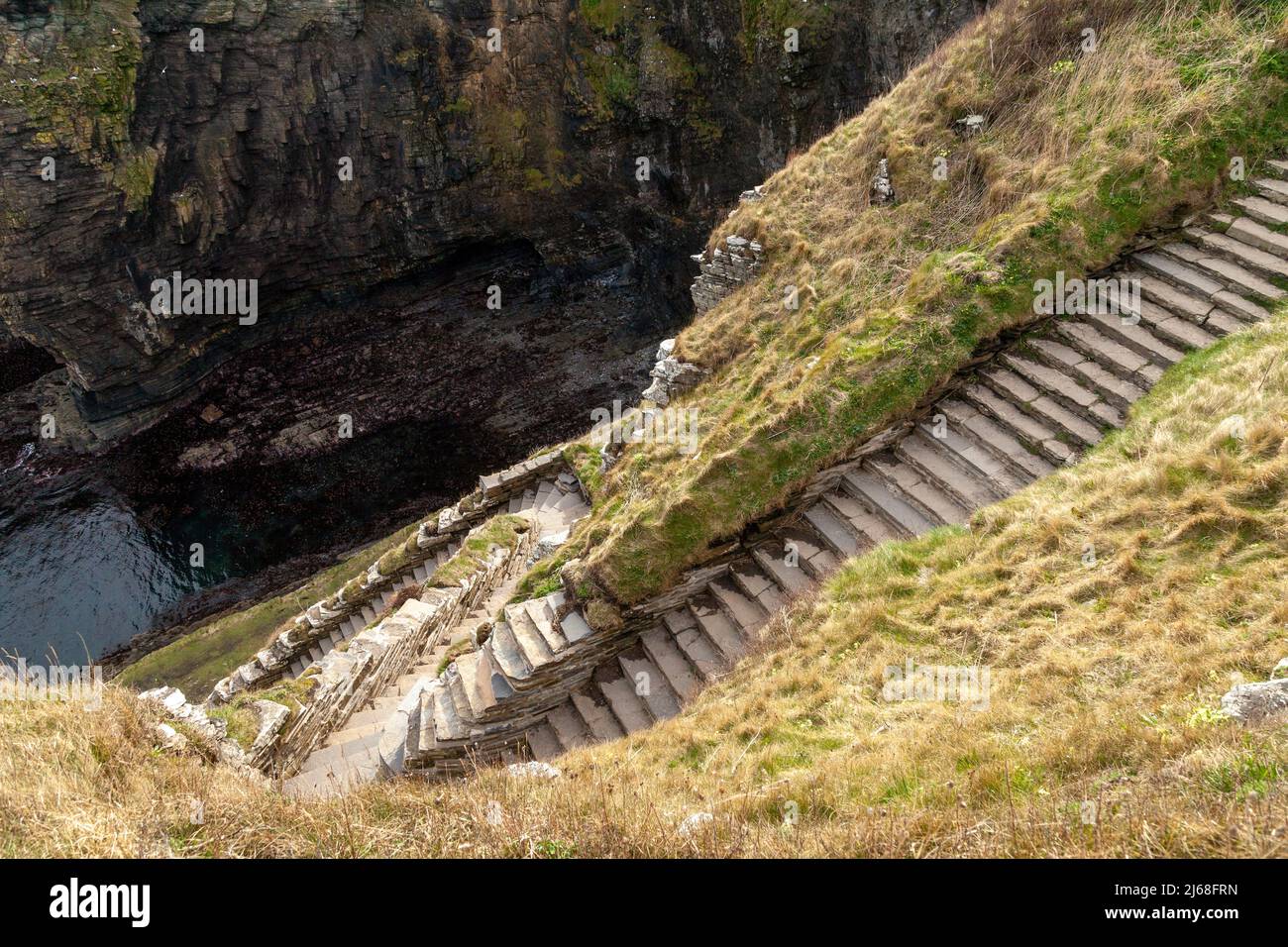 Whaligoe scalini zigzag giù la parete di scogliera 250ft per darvi l'accesso a Whaligoe Haven Foto Stock