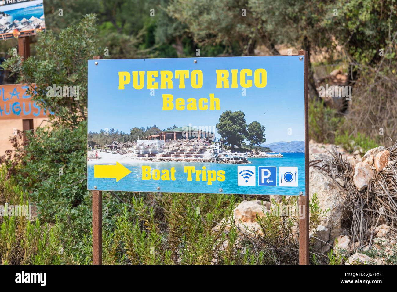 Ksamil, Albania - 9 settembre 2021: Cartello con la freccia per la spiaggia di Puerto Rico a Ksamil, Albania. Concetto di vacanza sfondo. Foto Stock