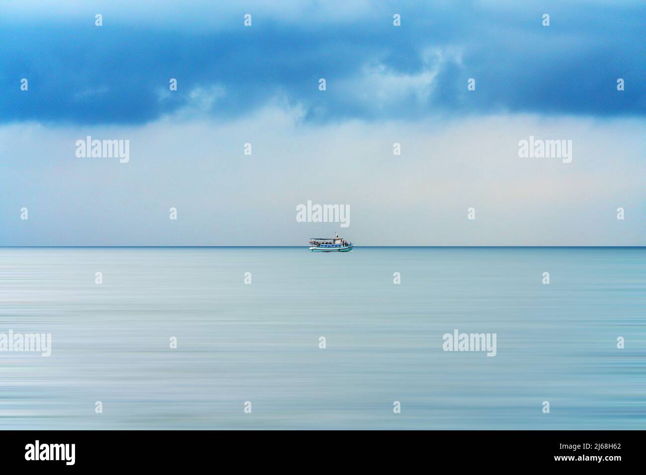 Barca da pesca sul mare con cielo blu brillante Foto Stock
