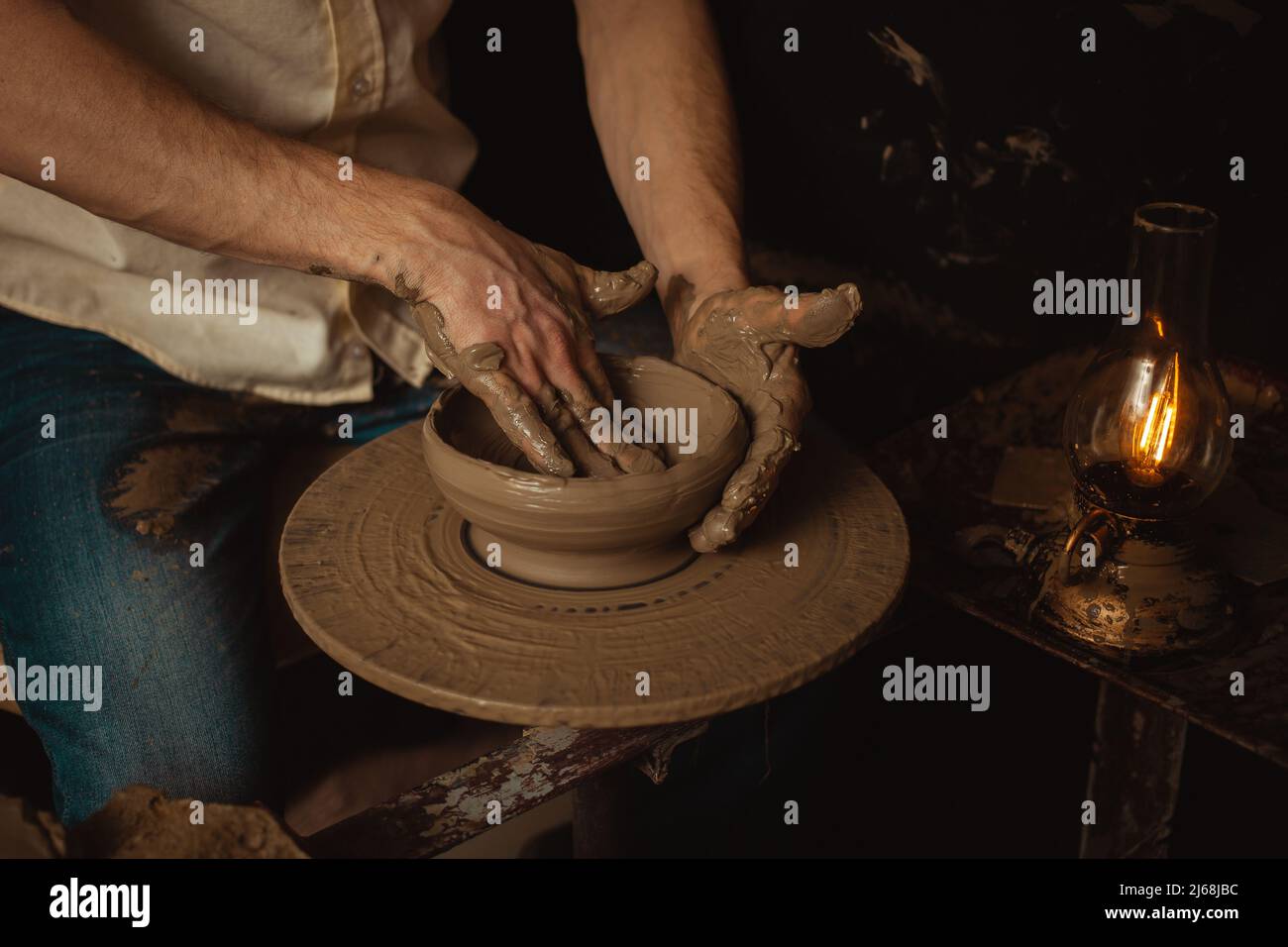 L'uomo fa piatto in laboratorio di ceramica, prodotto di argilla, atmosfera autentica, sfondo. Stile di vita, interni, primo piano, mani, naturale, ecologico Foto Stock