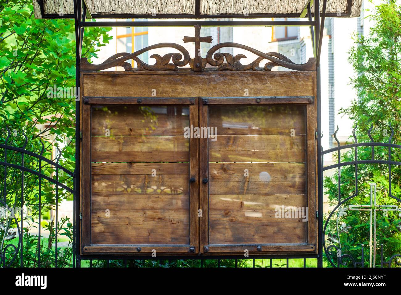 Chiesa legno vuoto bordo di preavviso sulla strada. Consiglio Parrocchiale esterno promemoria bordo dietro vetro. Vecchio stand in legno con croce per annunci o informazioni in città Foto Stock