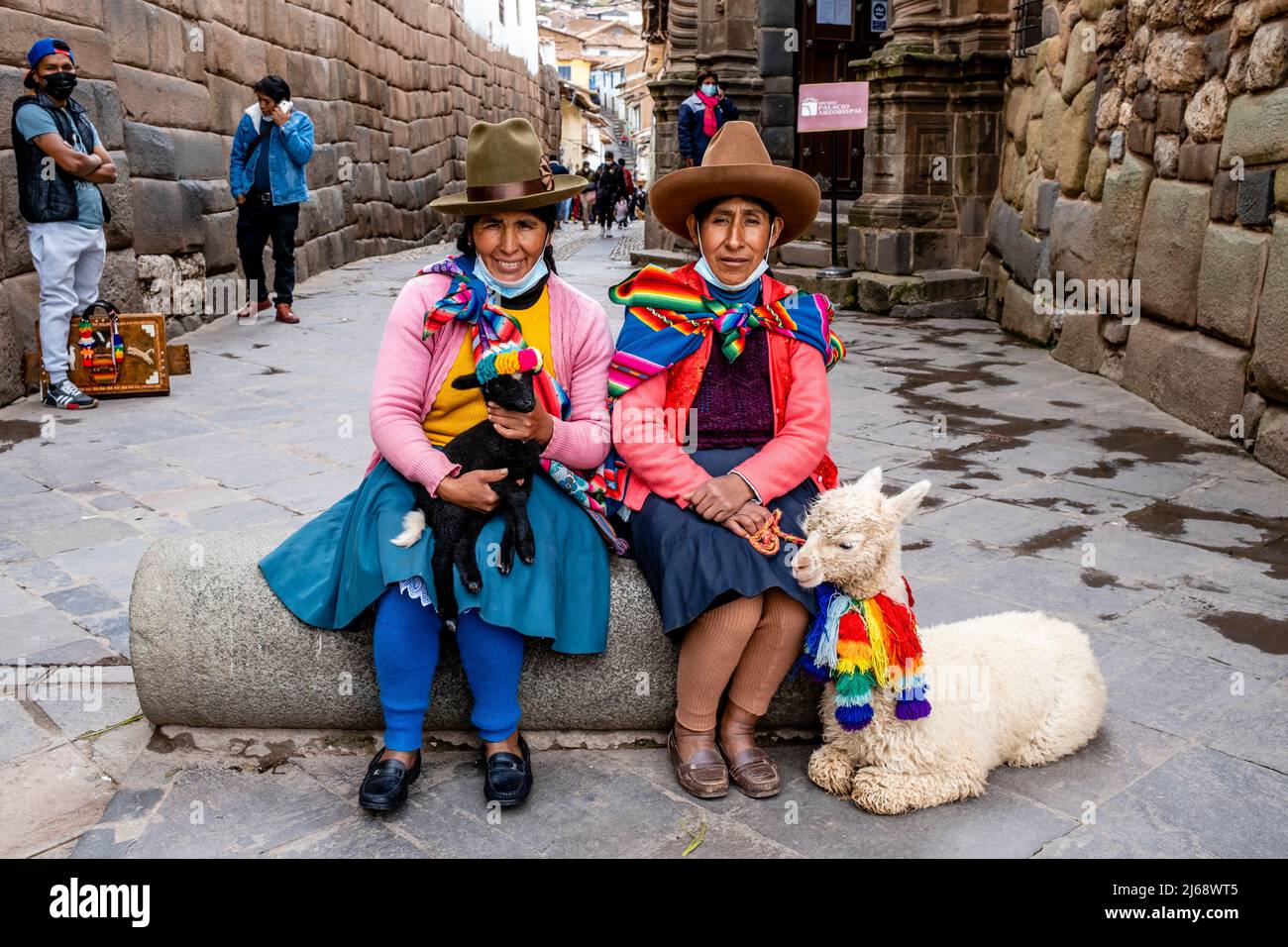 Due donne indigene in costume tradizionale posano con i loro Animali nel Centro storico di Cusco, Provincia di Cusco, Perù. Foto Stock