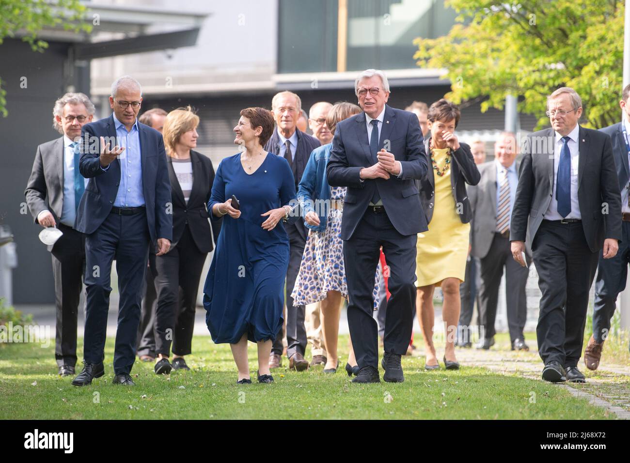 Darmstadt, Germania. 29th Apr 2022. 29 aprile 2022, Assia, Darmstadt: Tarek al-Wazir (Bündnis 90/Die Grünen, l-r), Ministro dell'economia e Vice primo Ministro dell'Assia, Silvia Castaner, Direttore amministrativo EUMETSAT, E Volker Bouffier (CDU), primo Ministro dell'Assia, camminano lungo un percorso di fronte ad altri membri del gabinetto e dell'EUMETSAT presso l'Organizzazione europea per lo sfruttamento dei satelliti meteorologici (EUMETSAT) prima di una riunione del gabinetto del governo di stato dell'Assia. EUMETSAT è un'organizzazione intergovernativa che gestisce i satelliti meteorologici. Foto: Sebastian Gollnow/dpa C. Foto Stock