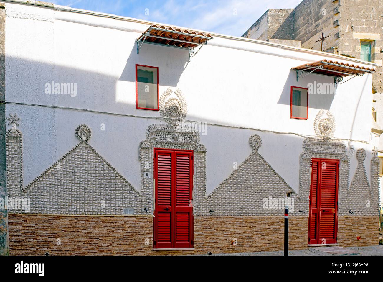 Parete decorativa di un piccolo edificio in via XXIV Maggio in piccola cittadina, Poggiardo, Salento, Puglia (Porgia), Italia. Foto Stock