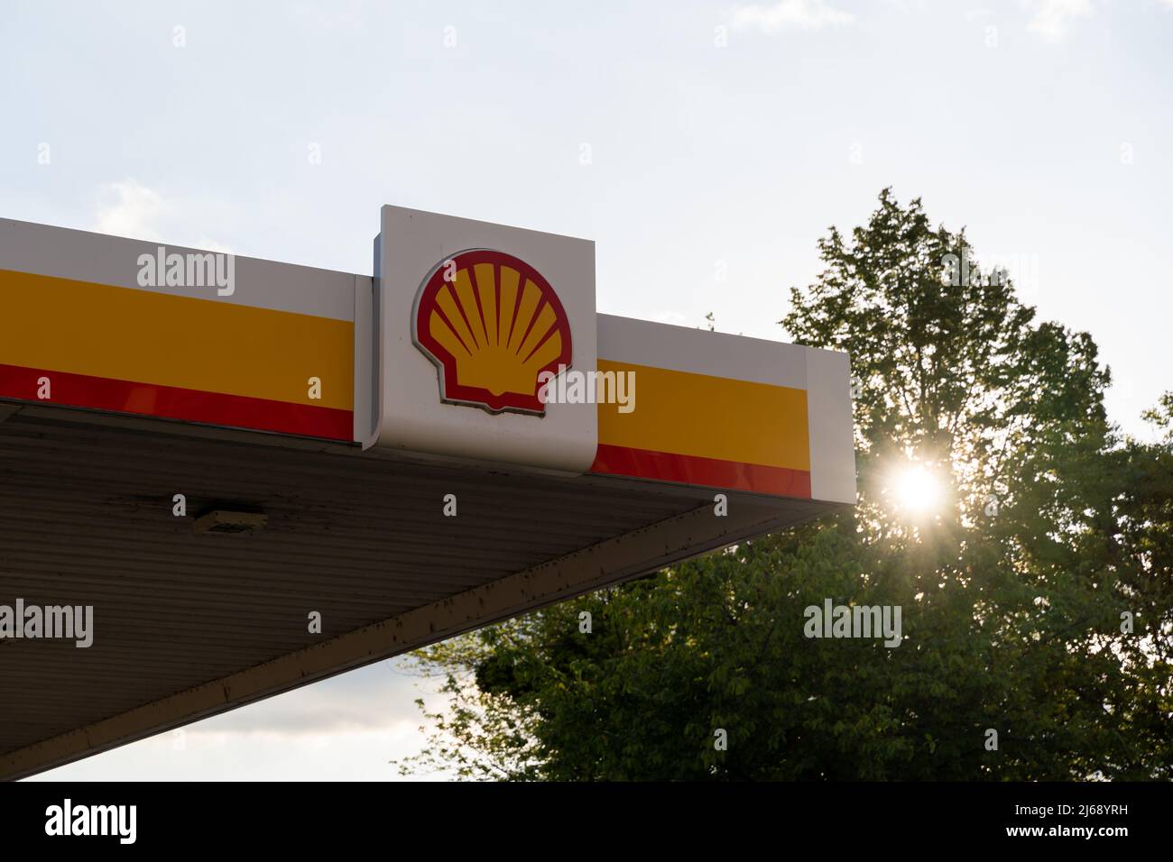 Stazione di servizio Royal Dutch Shell al tramonto. Grande logo sull'esterno di un edificio. Industria della benzina con un'attività nel settore dei trasporti e dell'energia. Foto Stock