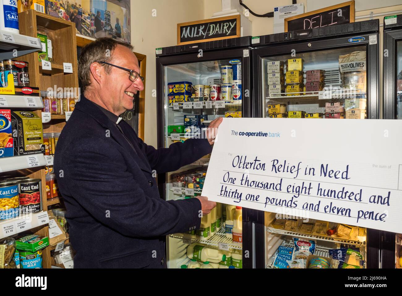 L'Otterton Community Shop presenta un assegno al Vicario per il Soccorso nel bisogno. Foto Stock