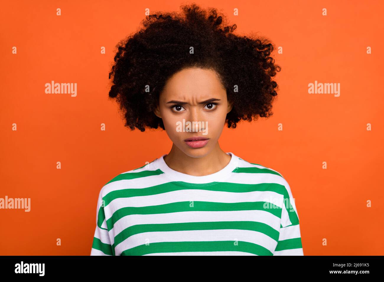 Ritratto di attraente brunet insoddisfatto ragazza cattivo umore accovacciato isolato su sfondo di colore arancione chiaro Foto Stock