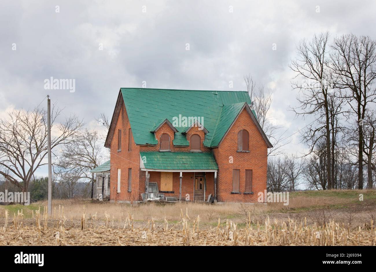 Una vecchia casa colonica abbandonata in primavera su un cortile in campagna Canada Foto Stock