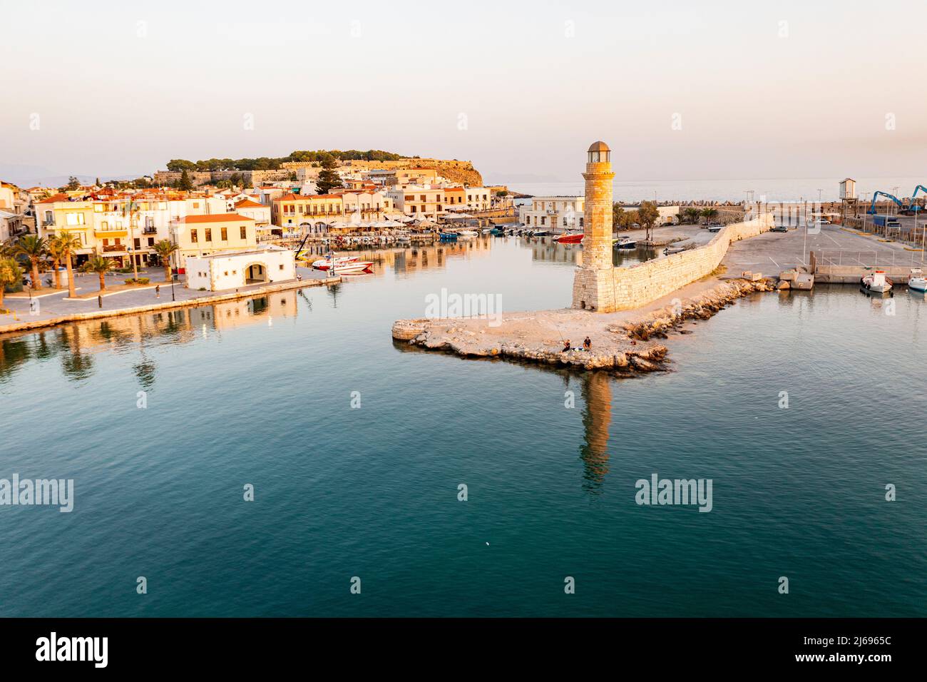 Vista aerea del mare calmo all'alba che circonda il vecchio porto veneziano e il faro, Rethymno, isola di Creta, Isole greche, Grecia, Europa Foto Stock