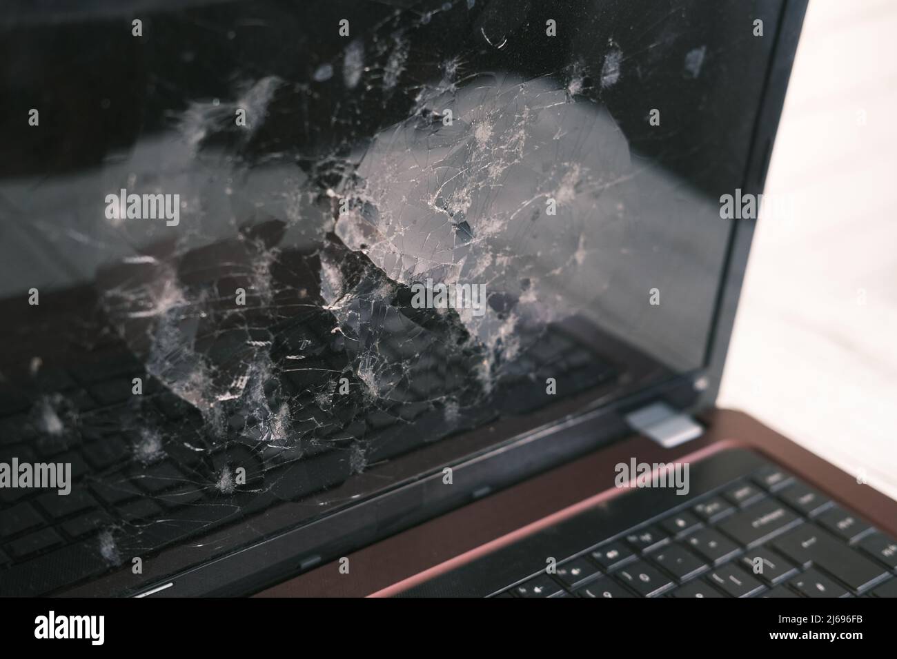 schermo del laptop rotto sul tavolo da vicino Foto Stock