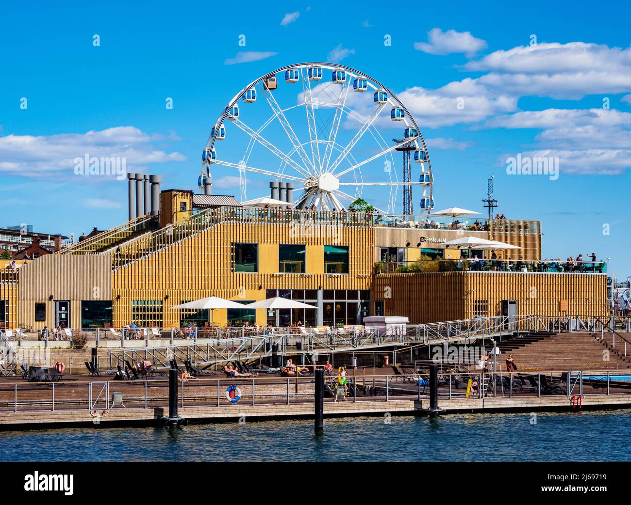 Vista su South Harbour verso Allas Sea Pool and Restaurand e SkyWheel Ferris Wheel, Helsinki, contea di Uusimaa, Finlandia Foto Stock