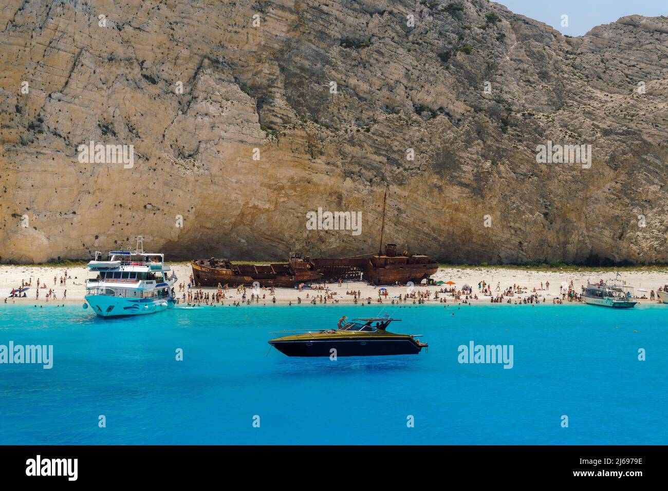 Naufragio sulla spiaggia di Navagio, una famosa spiaggia con acque cristalline, barche da diporto e bagnanti ormeggiati, Zante, Isole IONIE, Isole Greche Foto Stock