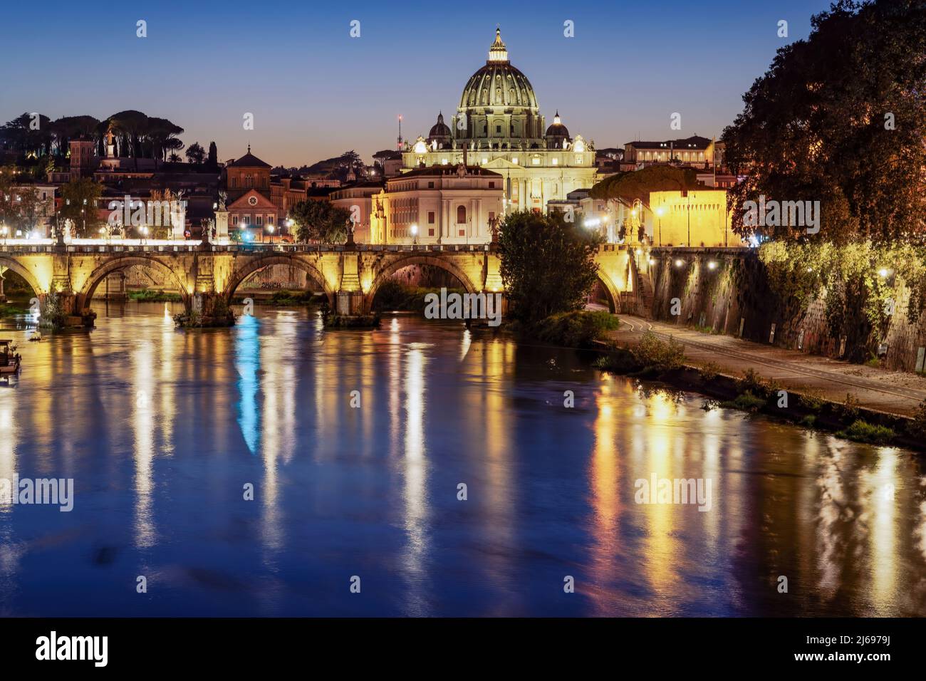 Vista notturna del Ponte di San Angelo sul Tevere con sfondo della Basilica di San Pietro illuminata in Vaticano, Roma, Lazio, Italia, Europa Foto Stock