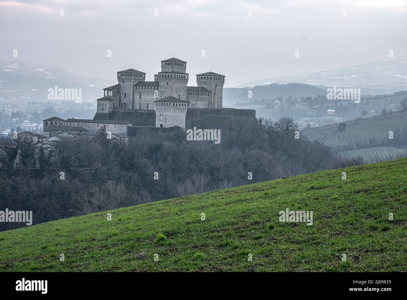 Castello medievale di Torrechiara con torri quadrate su una collina in un giorno di nebbia, Torrechiara, Emilia Romagna, Italia Foto Stock