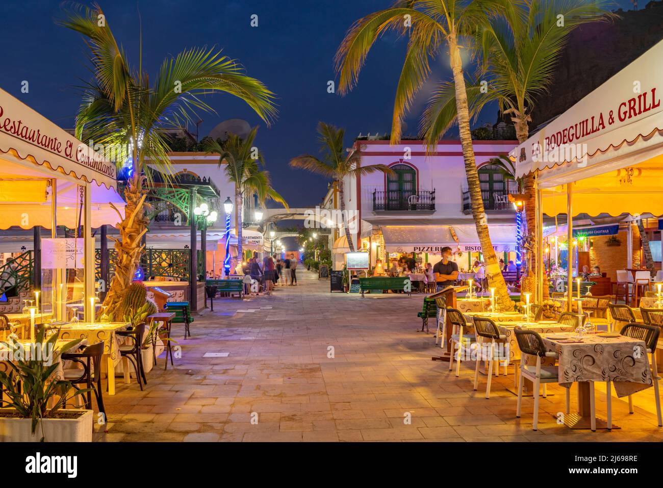 Vista di caffè e ristoranti a Puerto de Mogan e sfondo montuoso al tramonto, Puerto de Mogan, Gran Canaria, Isole Canarie, Spagna, Atlantico Foto Stock