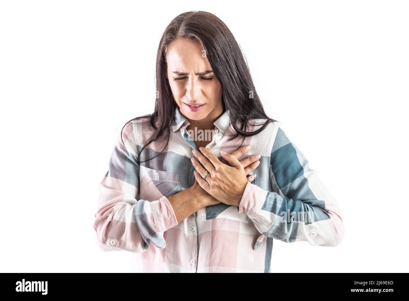 Giovane donna con mani sul petto con aritmia cardiaca. Isolato su bianco. Foto Stock