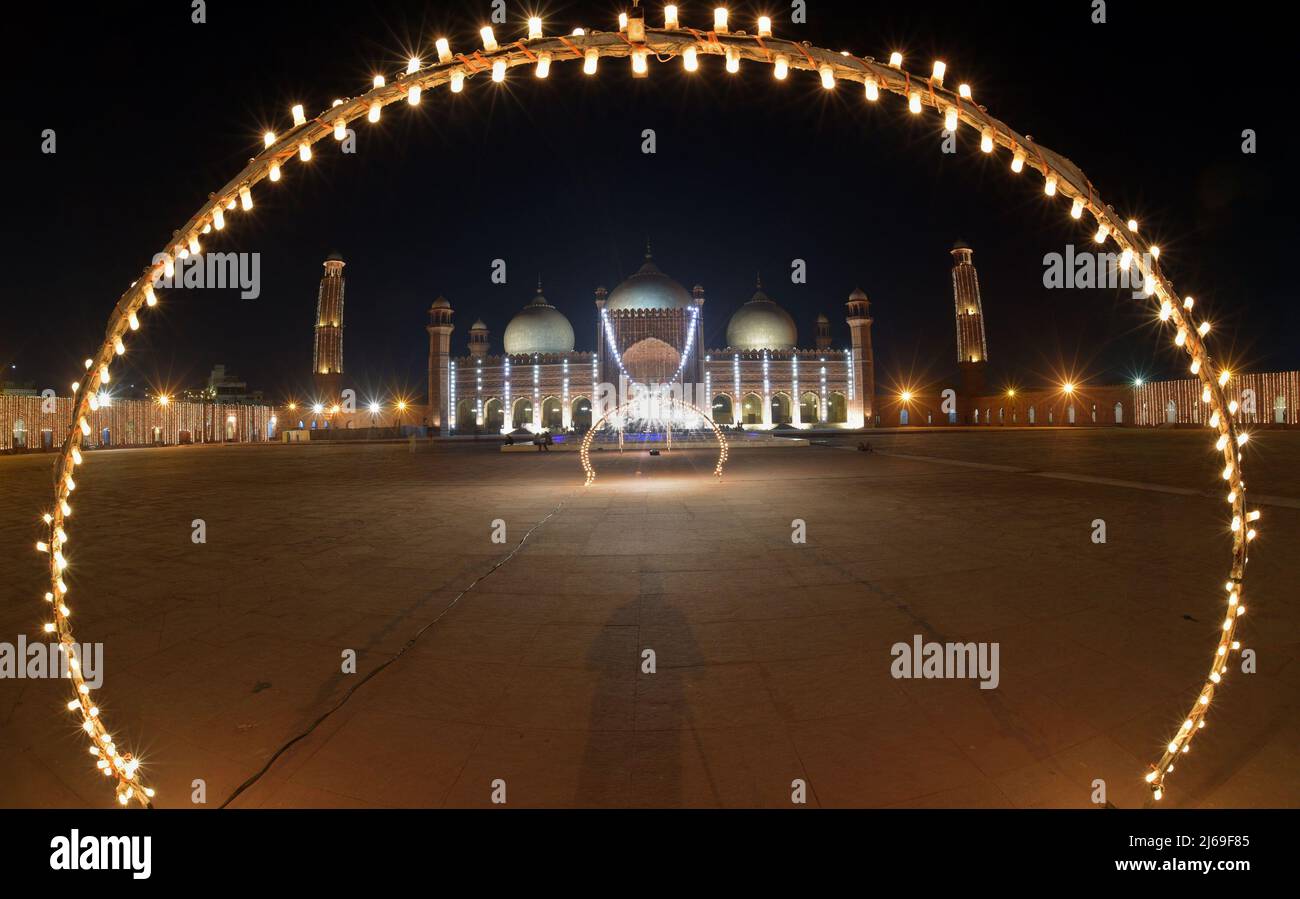 Una splendida e attraente vista aerea della storica moschea Badshahi dell'era Mughal decorata con luci per segnare la notte Santa e cercare le benedizioni divine di Lailatul Qadr, anche conosciuta come la Notte del potere a Lahore. Laylat ul Qadr o comunemente noto come Shab-e-Qadr, la “Notte del potere” è piena di benedizioni perché l’eminente Corano vi discese, i fedeli musulmani arrivano ad offrire preghiere serali 27th notti del mese Santo del Ramadan in una Moschea Badshahi illuminata” secondo la tradizione, Quando il libro sacro musulmano, il Corano, fu rivelato al profeta Maometto attraverso l'angelo Gabrie Foto Stock