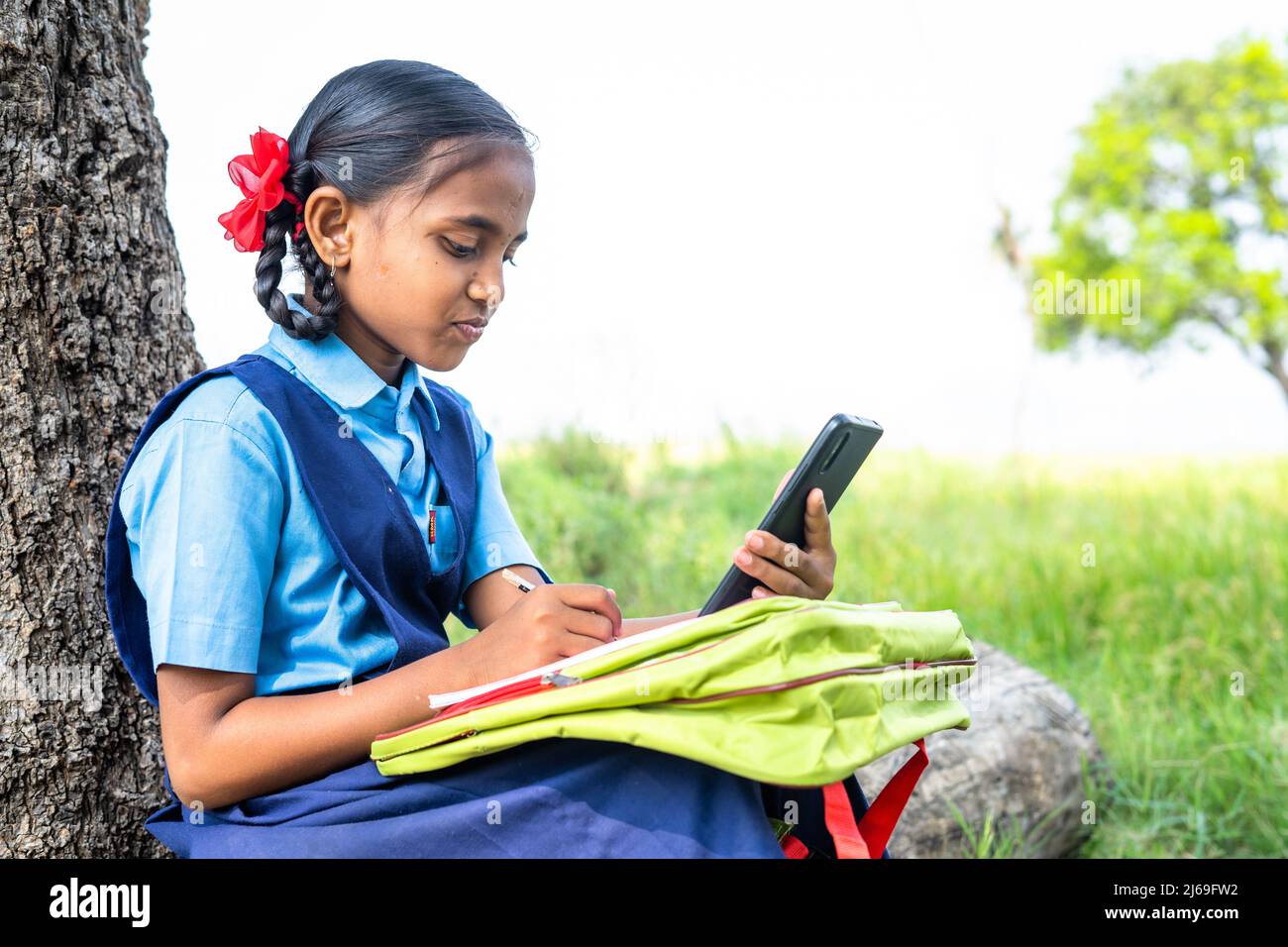 adolescente scuola ragazza capretto vicino agricolo farma ascoltare classe online - concetto di apprendimento a distanza, assistenza virtuale e istruzione. Foto Stock