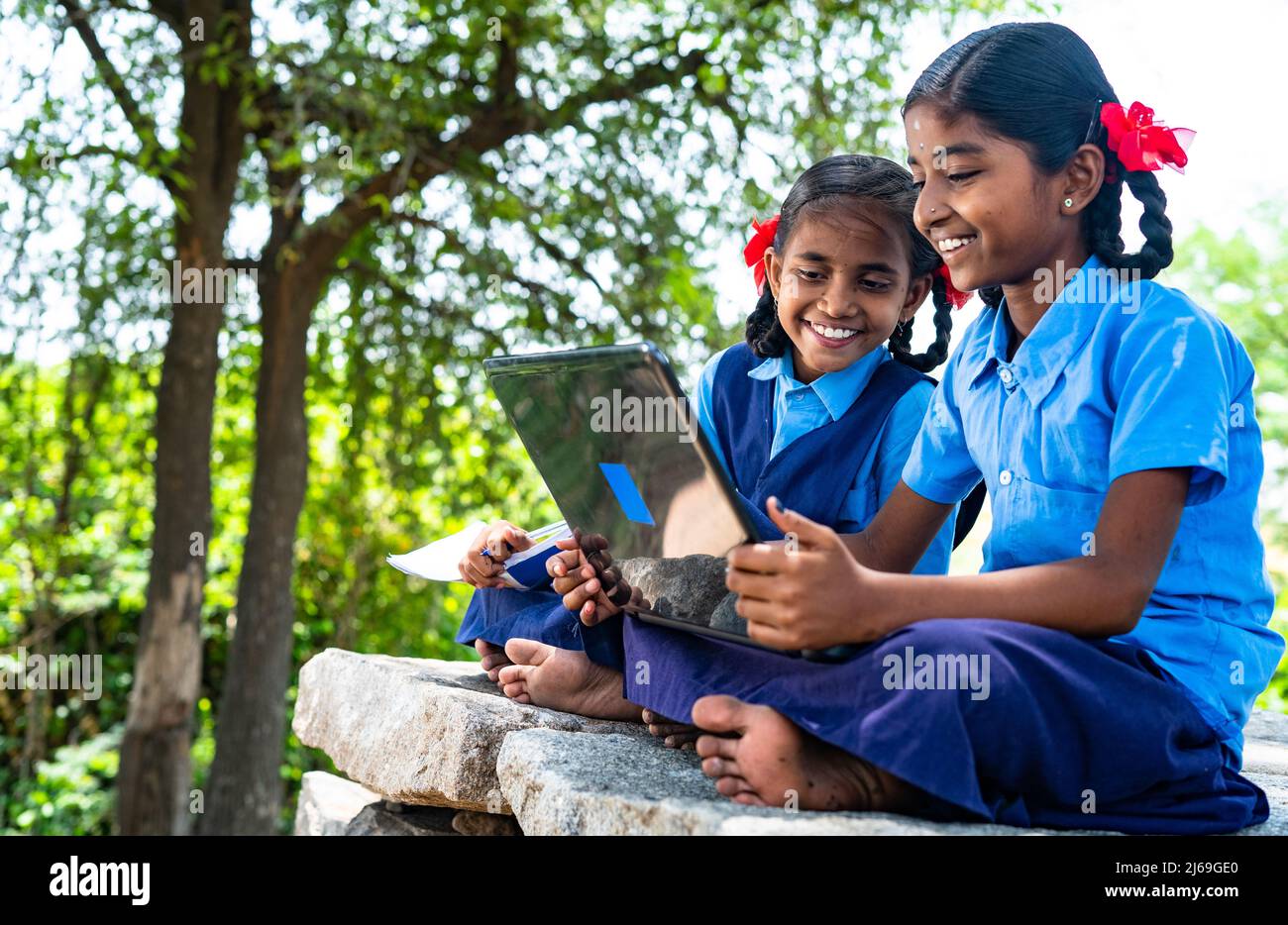 Foto portatile della scuola Village ragazzi seriamente occupato a lavorare sul laptop - concetto di istruzione, tecnologia e conoscenza Foto Stock