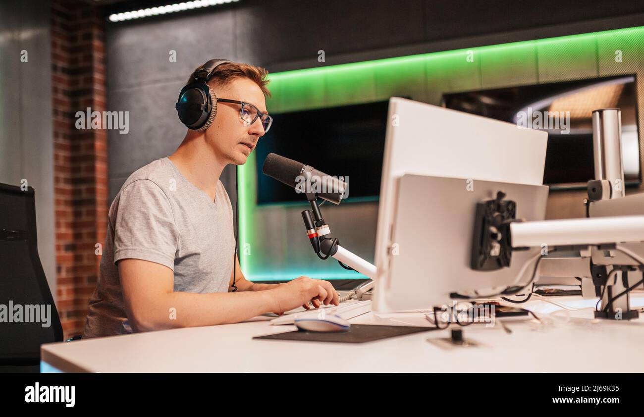 Il DJ ospita il programma e comunica con il pubblico in onda alla stazione radio. L'annunciatore legge la notizia. Un host radio maschio parla in un Foto Stock