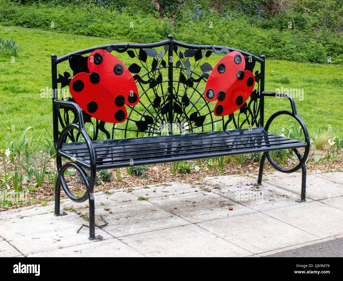 Iron Ladybird panchina in un parco pubblico nel distretto Henleaze di Bristol UK Foto Stock