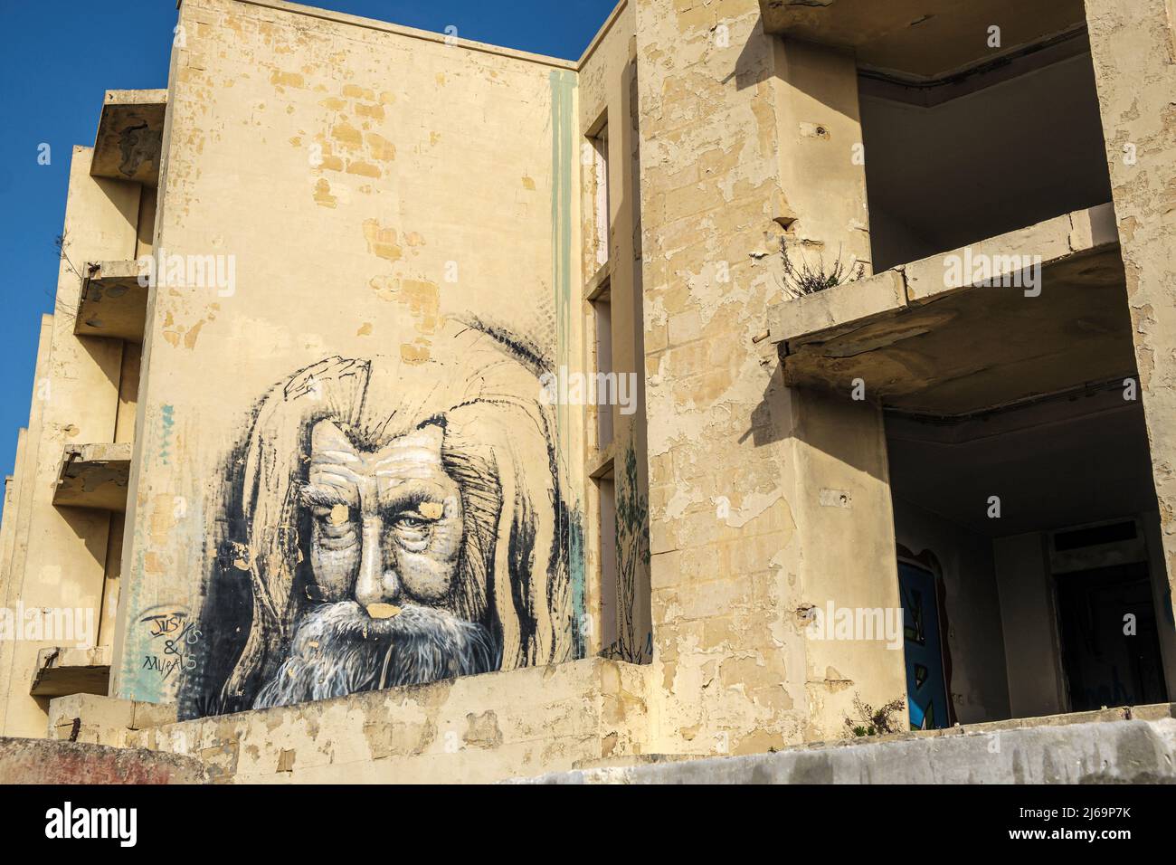 Murale di un uomo barbuto su un muro dell'abbandonato Jerma Palace Hotel, Marsaskala, Malta Foto Stock