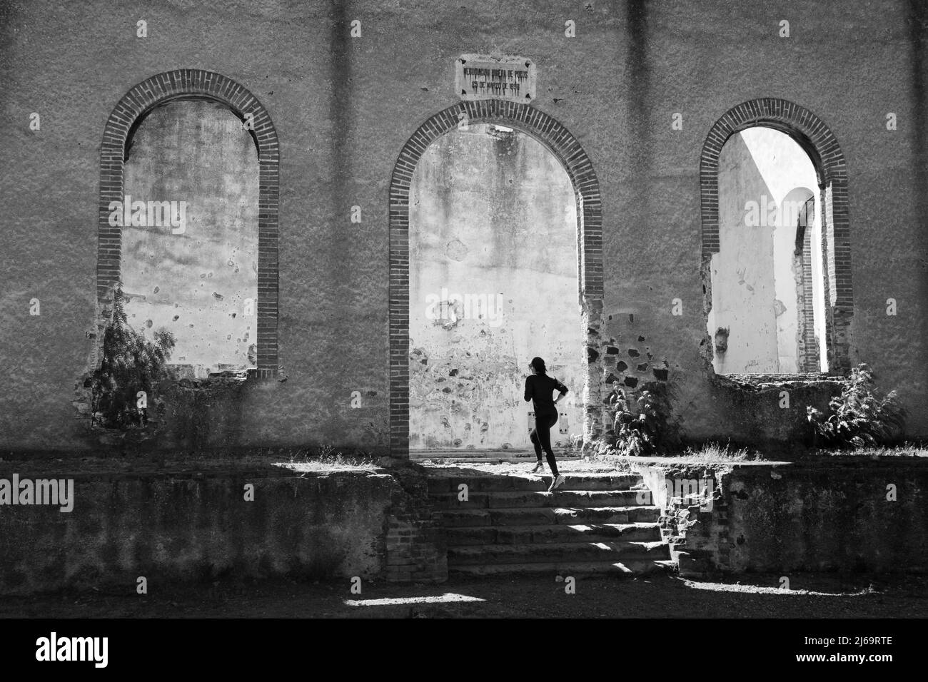 Donna che corre sulle scale alle rovine di Santa Brigida Hacienda Foto Stock