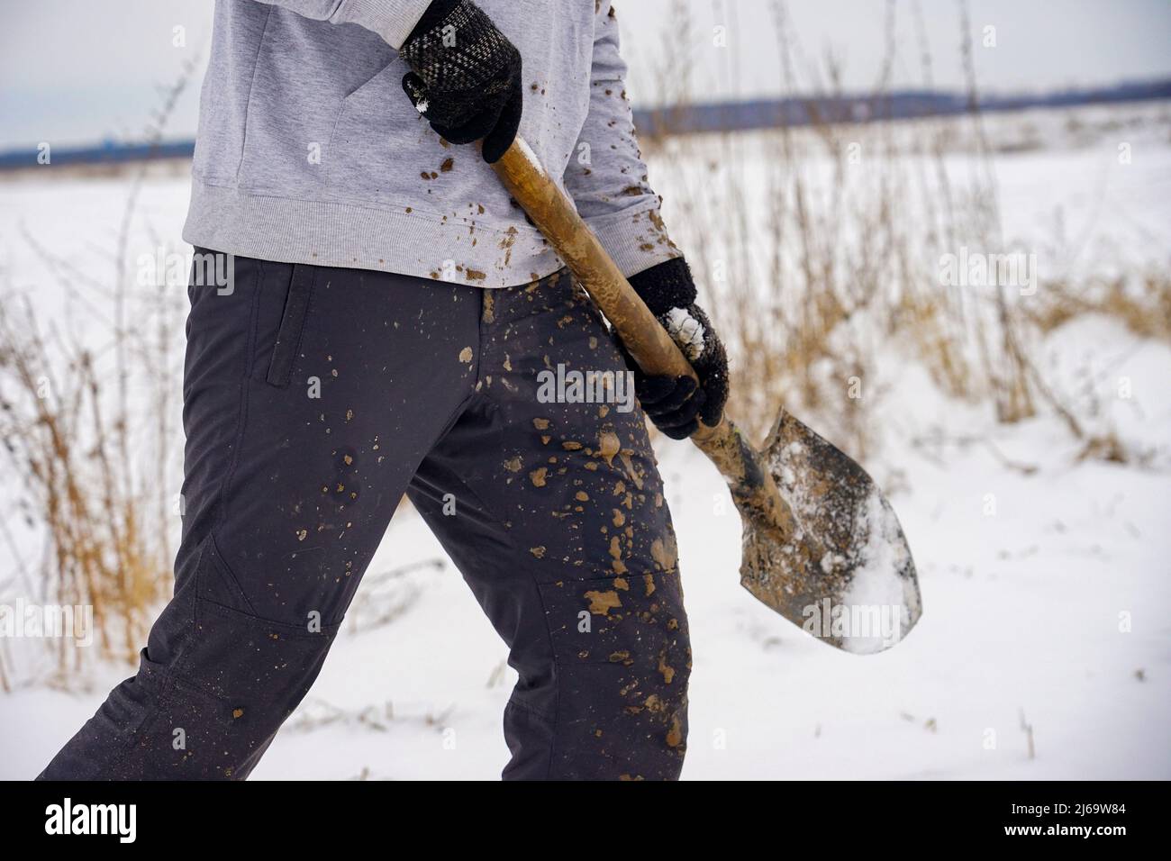 Ragazzo in abiti sporchi con una pala nelle sue mani Foto Stock