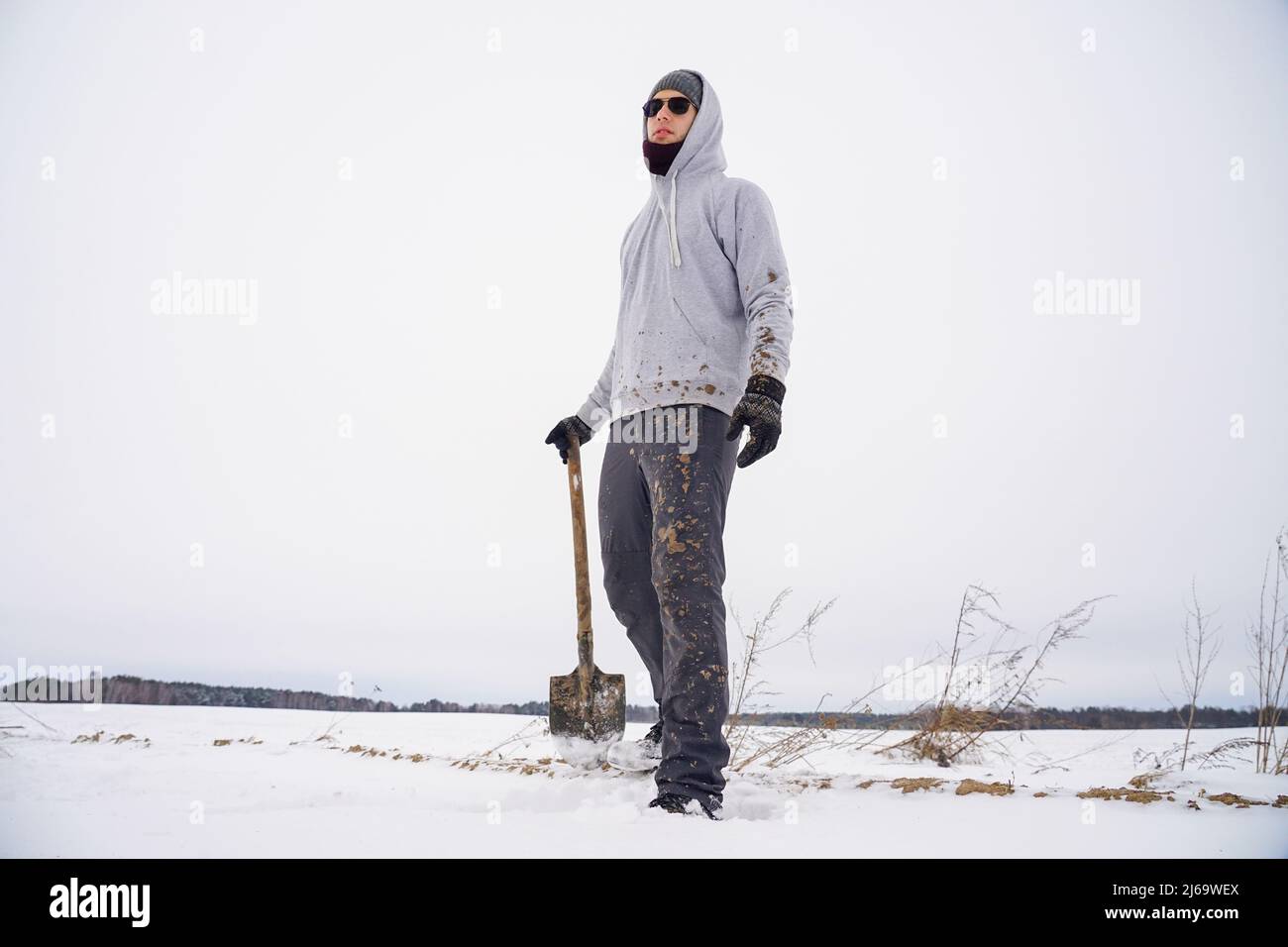 Ragazzo in abiti sporchi con una pala nelle sue mani Foto Stock