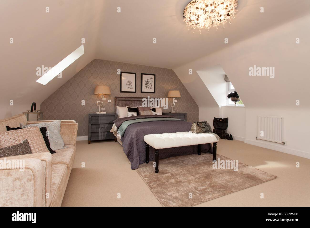 Loft conversione camera da letto con divano, letto e finestre dormer su entrambi i lati. Foto Stock