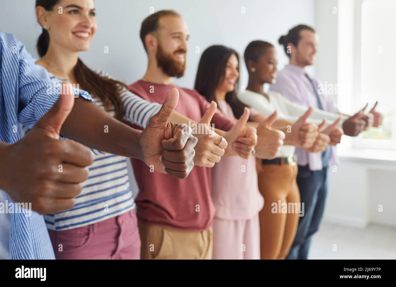 Gruppo multirazziale di giovani felici che sorridono e mostrano i pollici tutti insieme Foto Stock