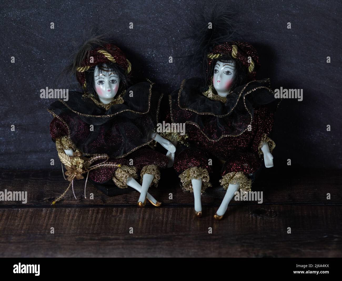 Giocattoli d'epoca in porcellana realistici con occhi grigi. Le bambole sono vestite con un abito da carnevale, decorato con oro. Vecchio stile italiano. Foto Stock