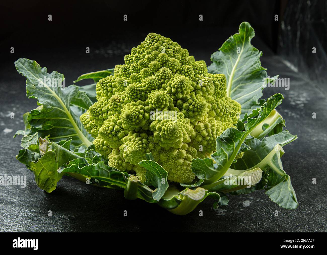 Romancio broccoli testa su una superficie di pietra scura, cavolo, primo piano, sequenza fibonacci, per chi ama la matematica, foto di scorta Foto Stock