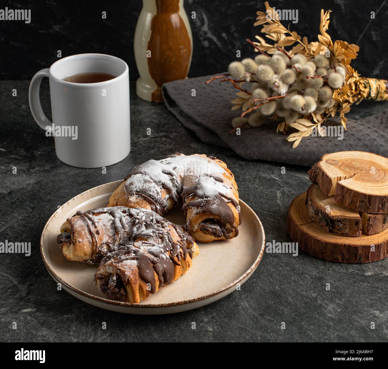 Tazza di tè nero, dolci al cioccolato tradizionali, salice, vaso di onice, legno su sfondo scuro, foto di scorta Foto Stock