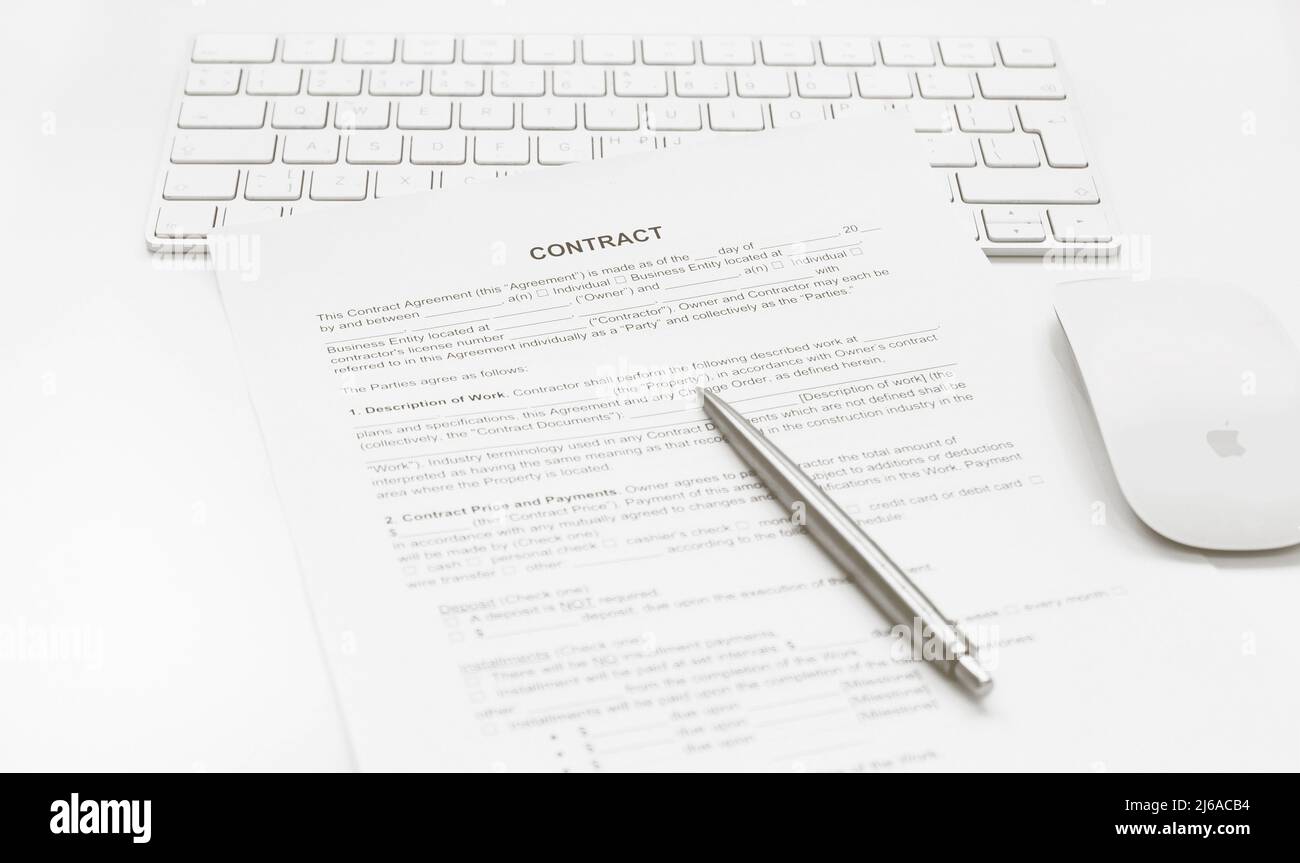 La penna per la firma del contratto sulla tastiera, mouse. Messa a fuoco selettiva Foto Stock