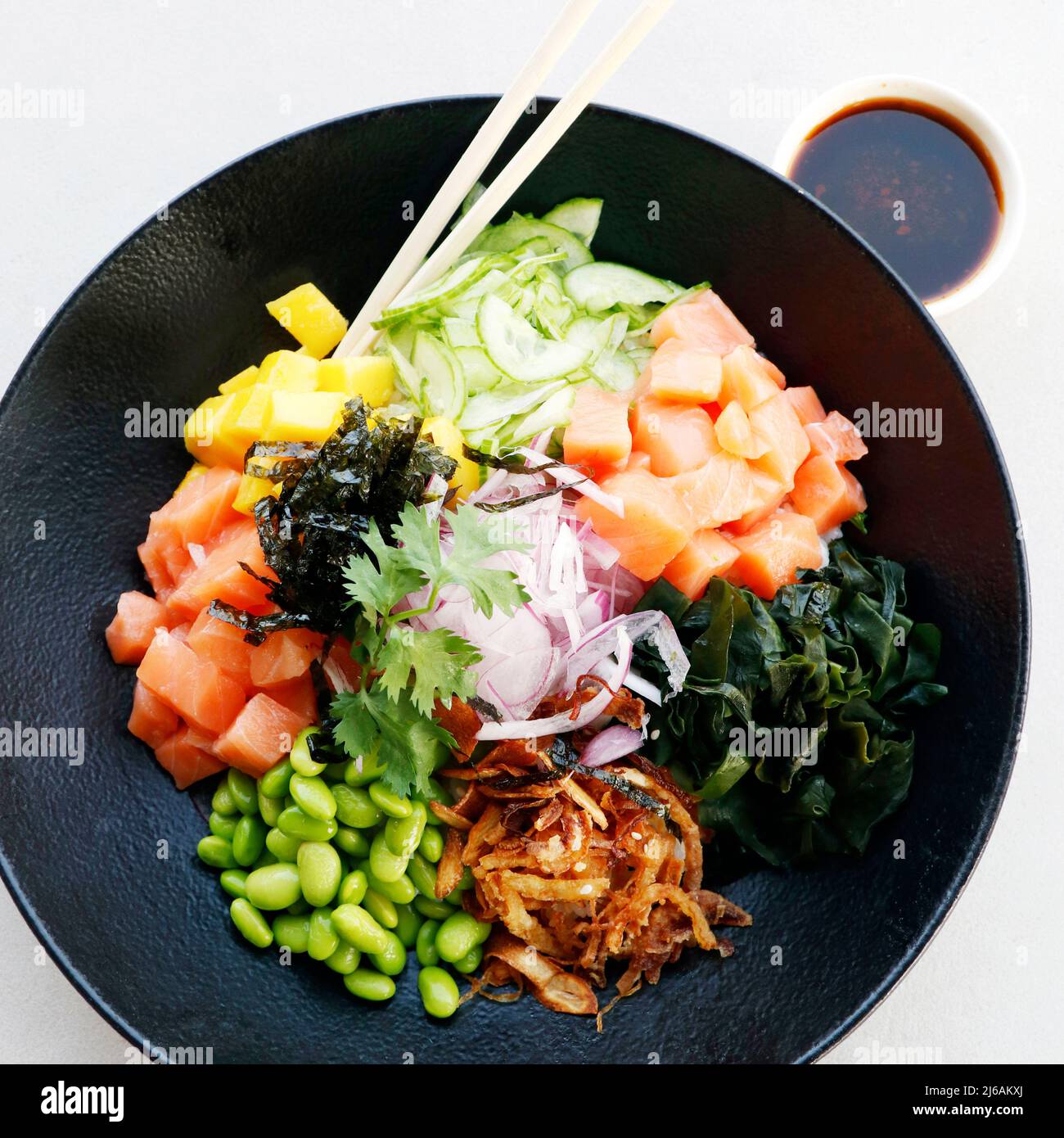 specialità culinarie giapponesi, ciotola di poke con salmone, verdure e riso Foto Stock