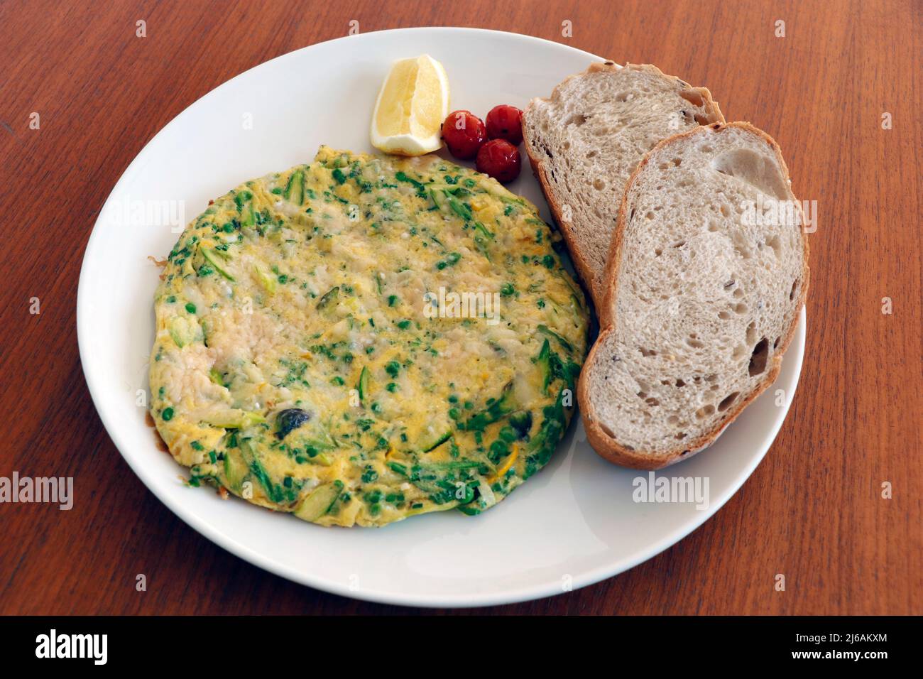 frittata di uova di verdure miste con pomodori, fette di pane Foto Stock
