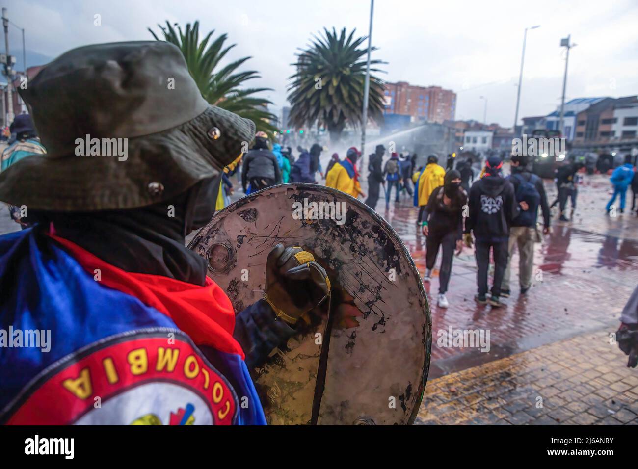 Un protester tiene uno scudo durante la dimostrazione. Gli studenti si scontrarono pesantemente con la polizia di sommosse all'università di Bogotá, mentre marciarono per commemorare il giorno in cui iniziò lo sciopero nazionale del 2021 in Colombia. Foto Stock