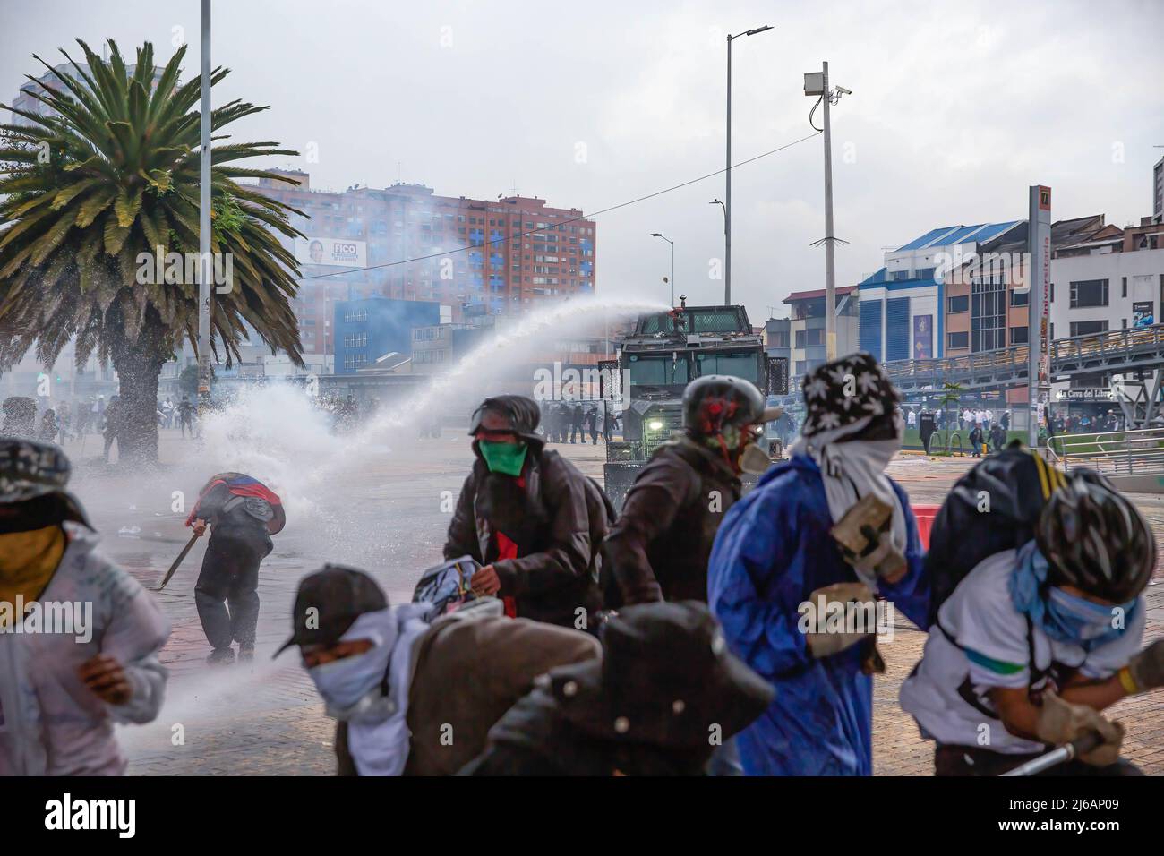 I manifestanti fuggono dai cannoni d'acqua durante la dimostrazione. Gli studenti si scontrarono pesantemente con la polizia di sommosse all'università di Bogotá, mentre marciarono per commemorare il giorno in cui iniziò lo sciopero nazionale del 2021 in Colombia. (Foto di Antonio Cascio / SOPA Images/Sipa USA) Foto Stock