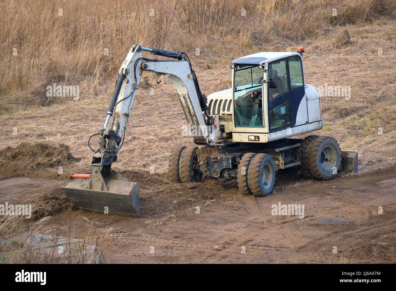 Trattore movimento terra che prepara il posto per la futura costruzione di fondamenta di case. Terreno livellante per la costruzione di nuova casa. Foto Stock