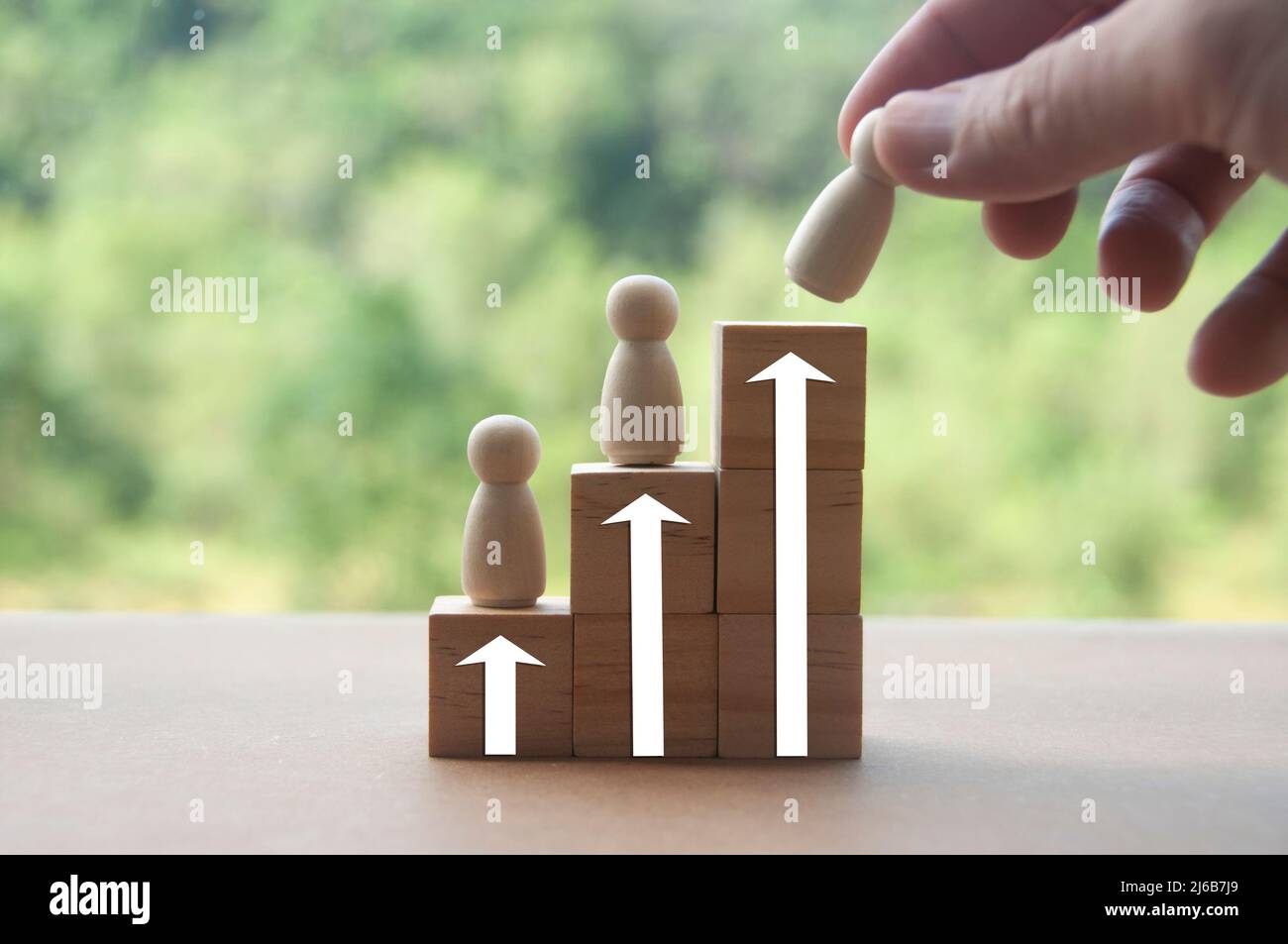 Mettere a mano bambola di legno su blocchi di legno impilati. Concetto aziendale di raggiungimento degli obiettivi. Foto Stock