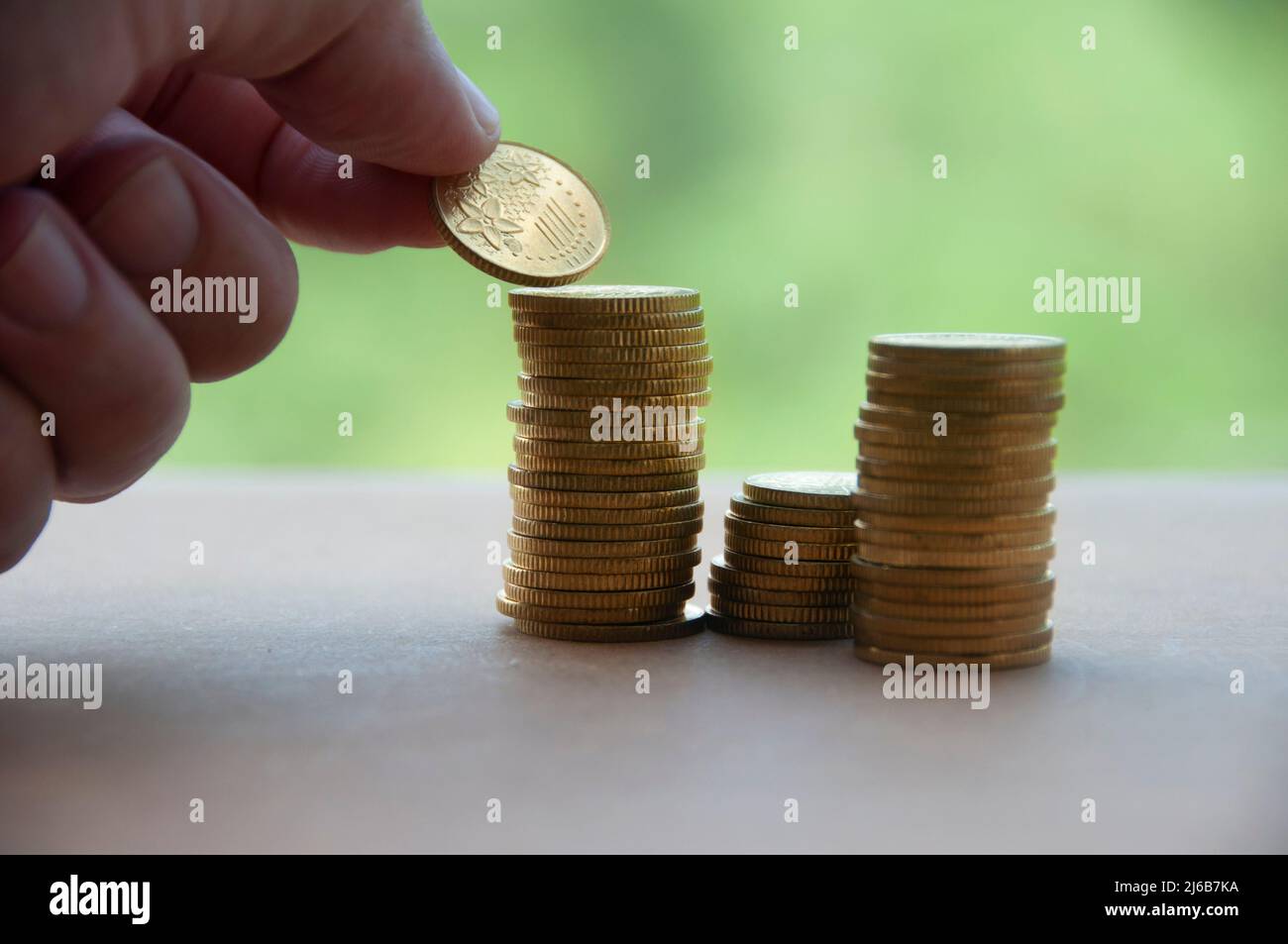Accatastare a mano le monete d'oro su sfondo di legno. Concetto di business e spazio di copia Foto Stock