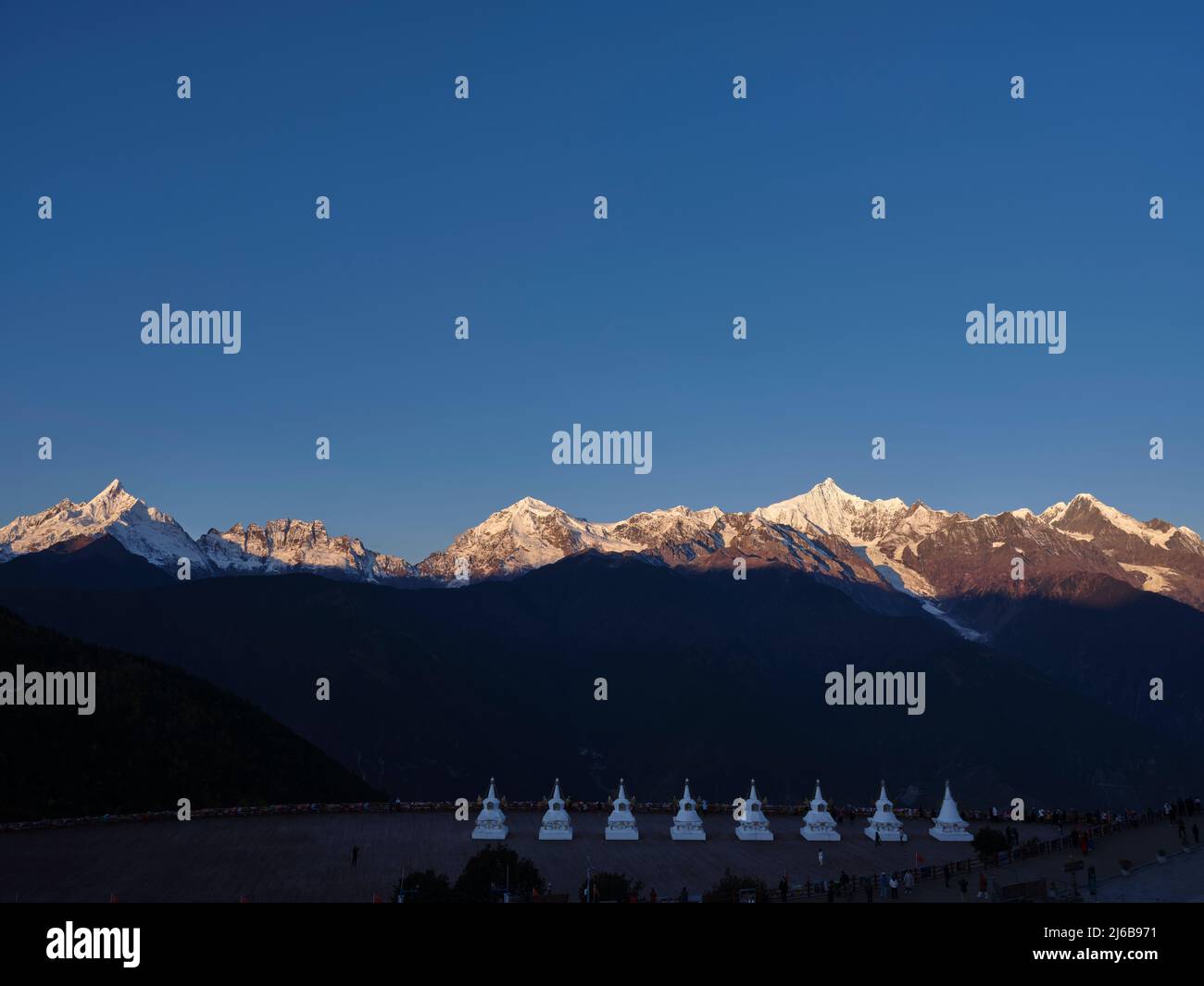 pagode bianche di tempio feilai con montagna di neve meili all'alba sullo sfondo nella provincia cinese di yunnan Foto Stock