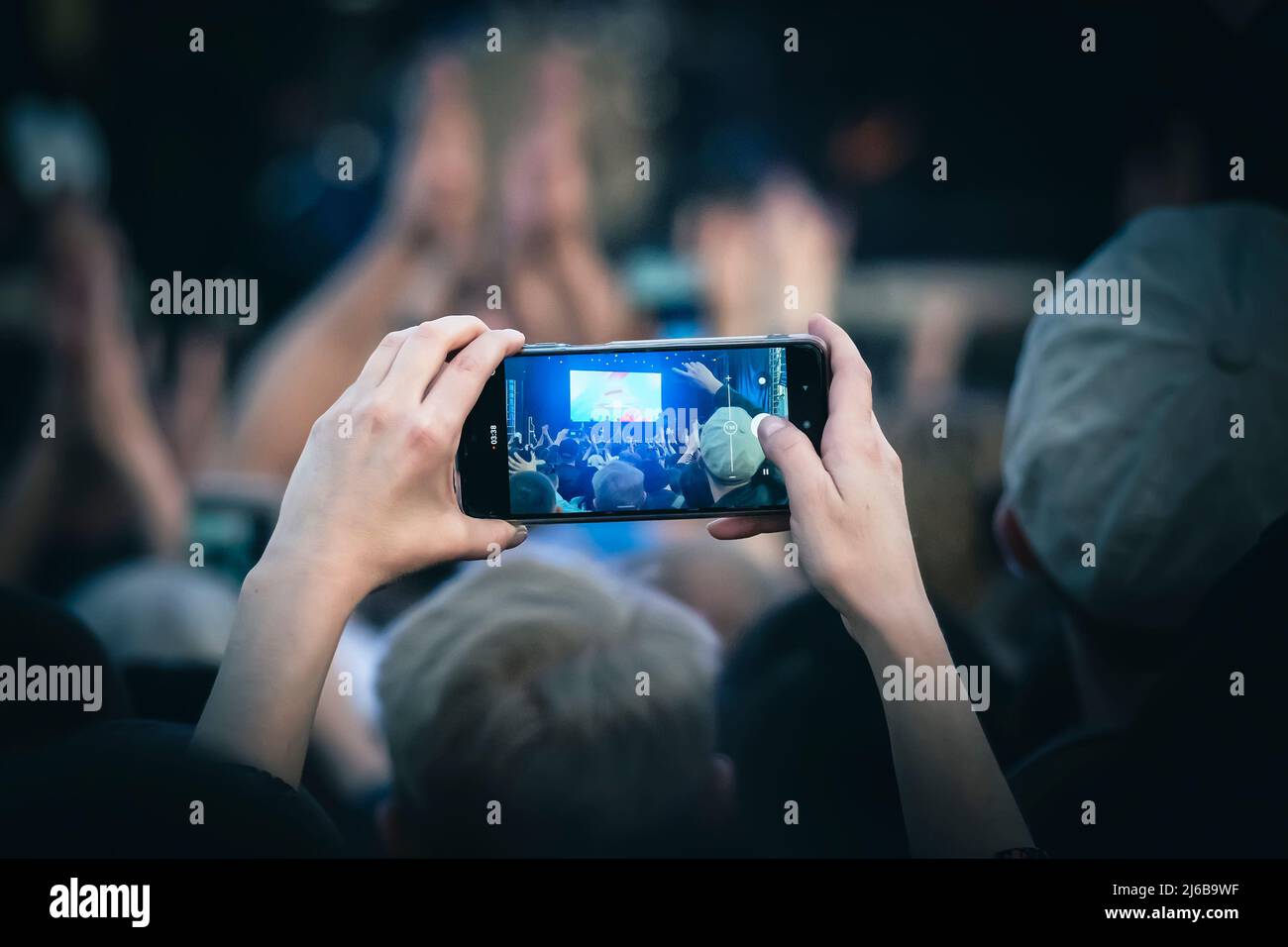 I giovani scattano foto o video di un concerto su smartphone. Foto Stock