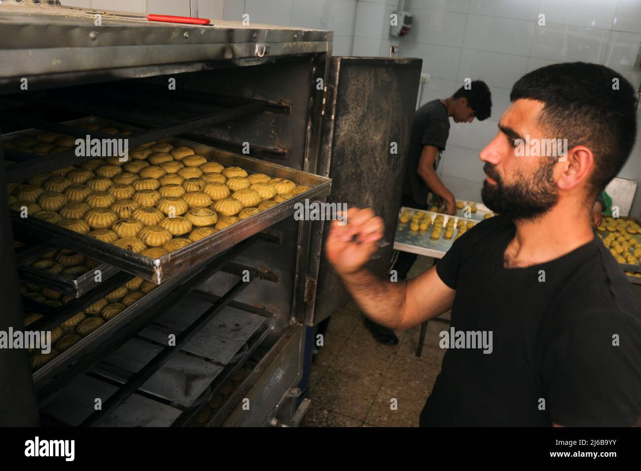 Il palestinese Ammar Abu Rumailah mette vassoi di dolci tradizionali di Eid  nel forno per cuocere prima di Eid al-Fitr nella città vecchia di Nablus,  nella Cisgiordania occupata da Israele, 27 aprile